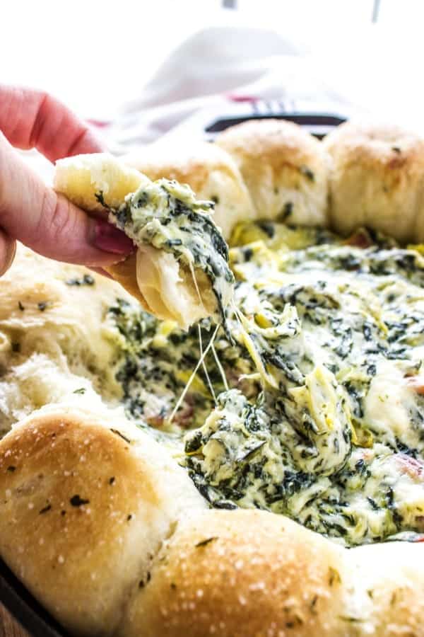 SPINACH ARTICHOKE BACON DIP RECIPE- creamy, delicious and easy to prepare this is a party must have. Adding bacon to your classic spinach artichoke dip is a fantastic twist that all your friends & family love. SPINACH ARTICHOKE BACON DIP RECIPE- Bite from dish displayed over iron skillet