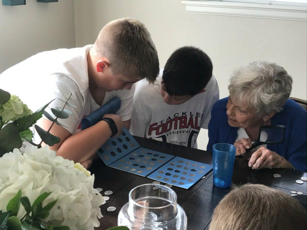 Sons Aiden and Madden with Grandma GiGi looking over coin collection 