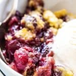 cherry cobbler in white bowl with ice cream