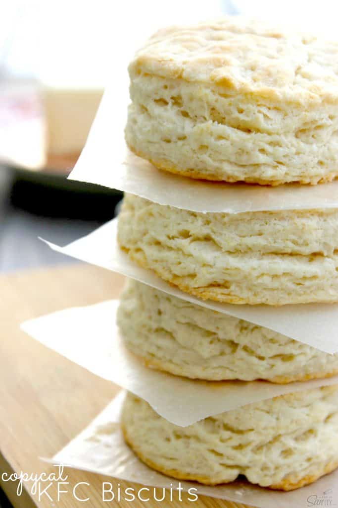 COPYCAT KFC BISCUITS photo of a stack of 4 Copycat KFC Biscuits with parchment between each one.