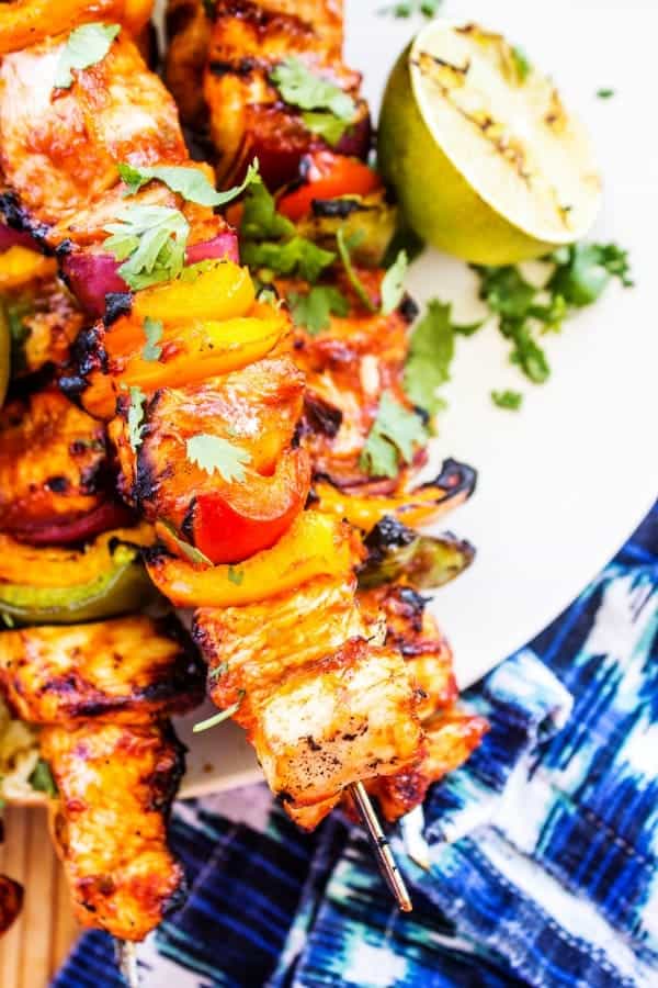 kabobs on plate with peppers and chicken and lime