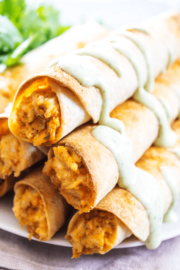 stack of taquitos drizzles in cilantro lime sauce