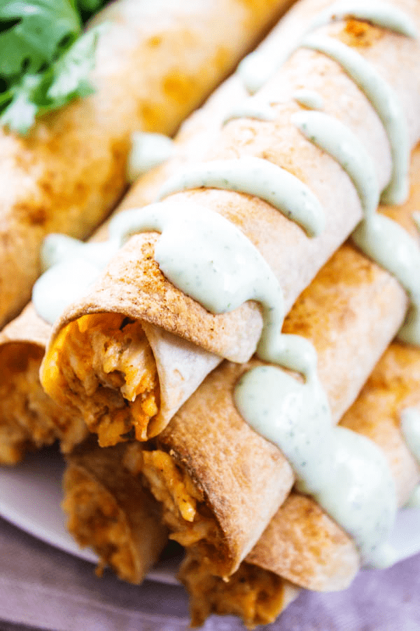 overhead shot taquitos on plate with cilantro dressing