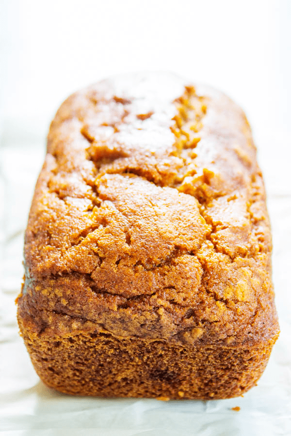 GLUTEN-FREE PUMPKIN BREAD - a quick bread that is deliciously spiced with nutmeg, cinnamon, & cloves. This fall treat is a family favorite. Close up of loaf of gluten-free pumpkin bread out of the pan