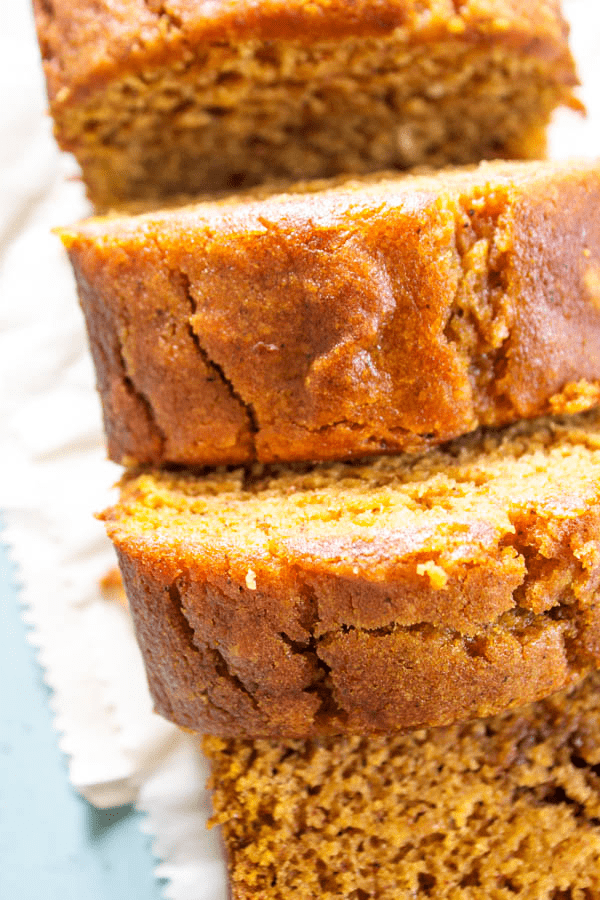GLUTEN-FREE PUMPKIN BREAD - a quick bread that is deliciously spiced with nutmeg, cinnamon, & cloves. This fall treat is a family favorite. Close up of sliced loaf of gluten-free pumpkin bread
