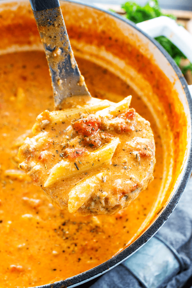 soup ladle with soup in pot with noodles 