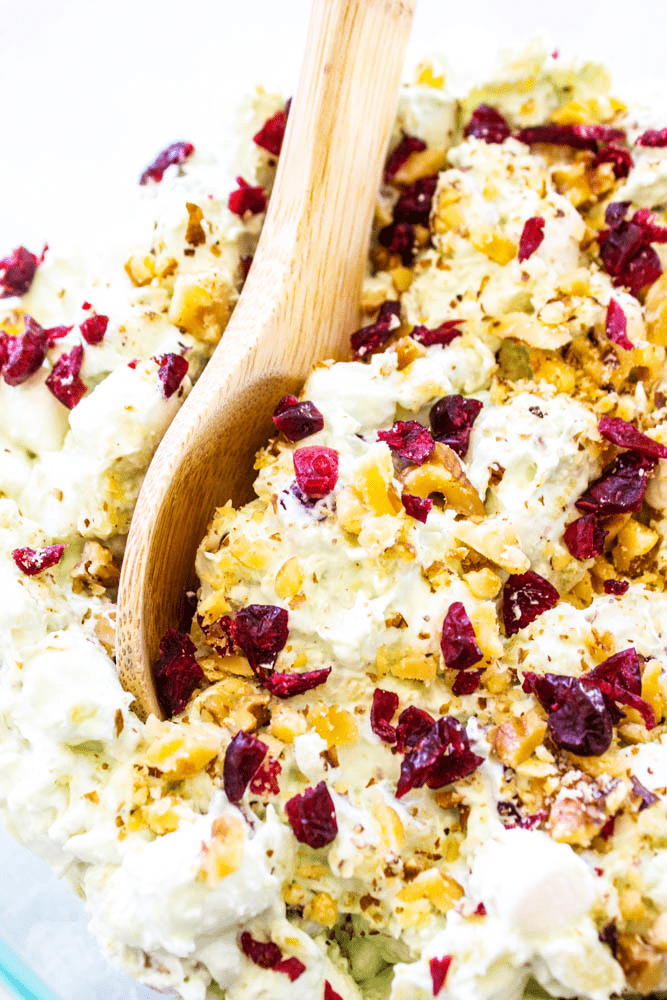 Watergate salad in a bowl with a wooden spoon.