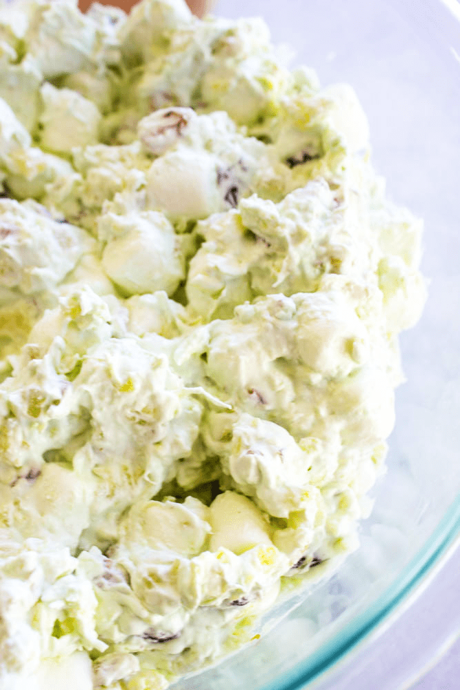 marshmallows, pudding, and cool whip mixed in a bowl.