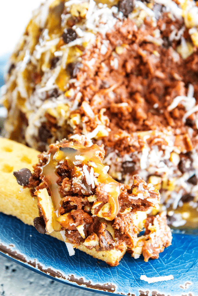 German Chocolate Cheesecake Ball with a scoop taken out with a cracker.