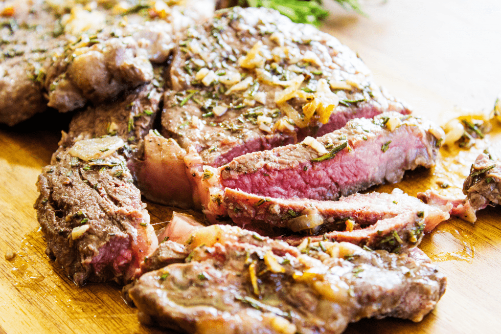 Sliced steak on a wooden cutting board