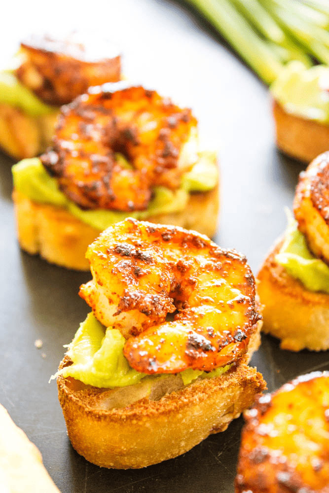 Simple, easy and insanely delicious, this recipe for CHILI RUBBED SHRIMP AND AVOCADO CROSTINI makes a great appetizer, snack or meal for busy nights. Chili Rubbed Shrimp and Avocado Crostinis on a platter