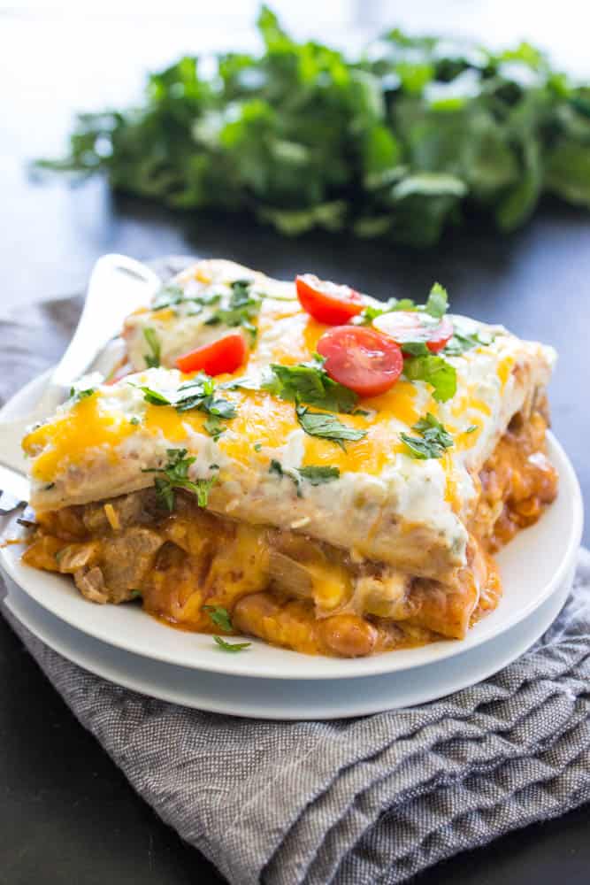 Steak and Queso Enchilada Casserole served on a small plate on top of a napkin