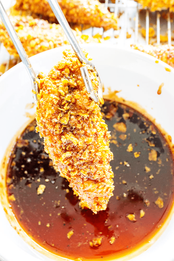 chicken tender being dipped into sauce
