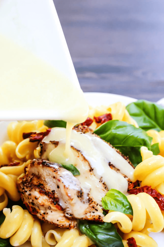 lemon butter sauce pouring over grilled chicken