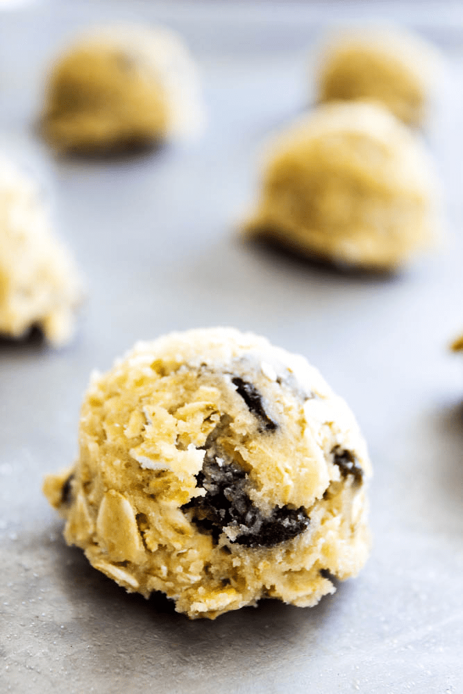 Oatmeal Raisin Cookie dough rolled into balls on a sheet pan