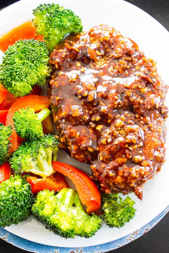 Cashew Oven-Fried Pork Chop served on a plate with oven roasted broccoli and red bell pepper slices