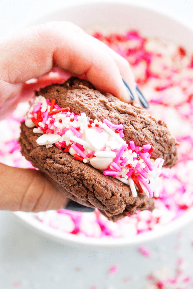 EASY WHOOPIE PIE RECIPE- Soft and chewy Devil's Food cake cookies sandwiched with cream cheese frosting, these whoopie pies are out of this world. up close view of Whoopie Pie rolled in sprinkles