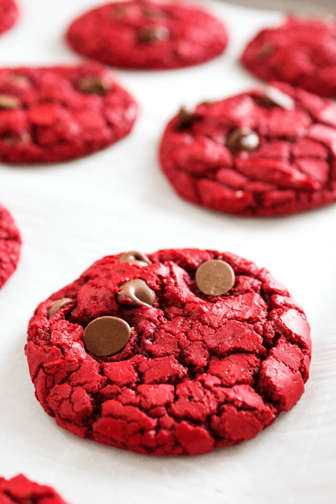 baked red velvet cookies on a sheet pan with parchment paper