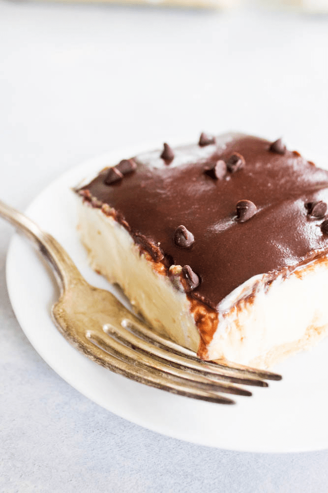 square slice of No-Bake Boston Cream Pie Cheesecake on a small plate with a fork