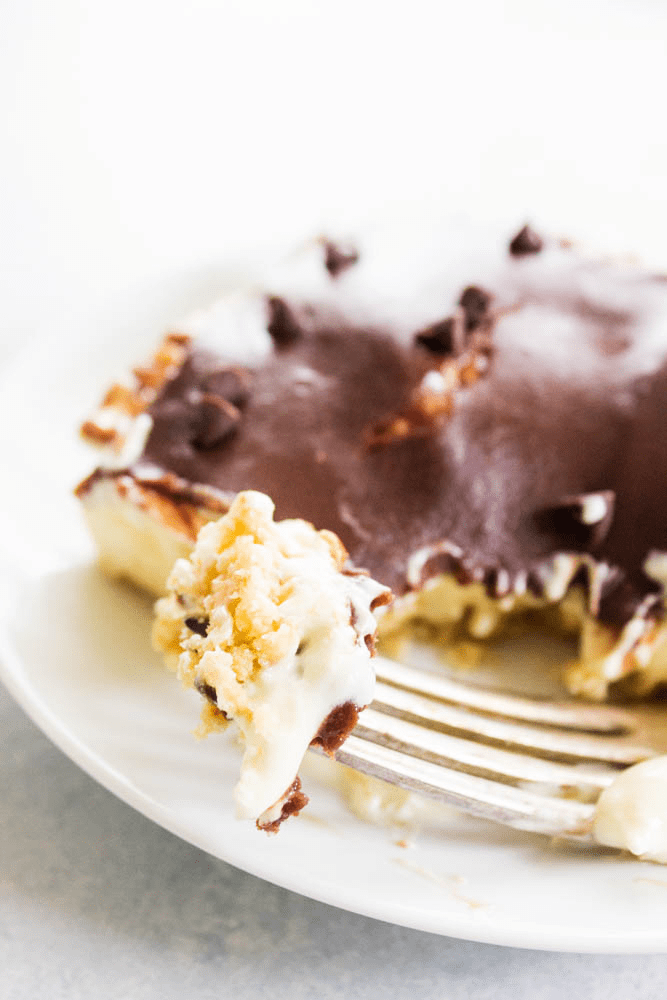 No-Bake Boston Cream Pie Cheesecake on a plate with a close up bite on fork