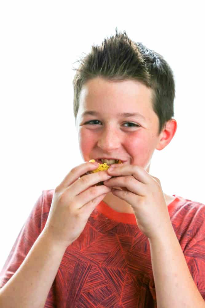 madden (young boy) taking a bite of a slice of Poppy Seed Cake