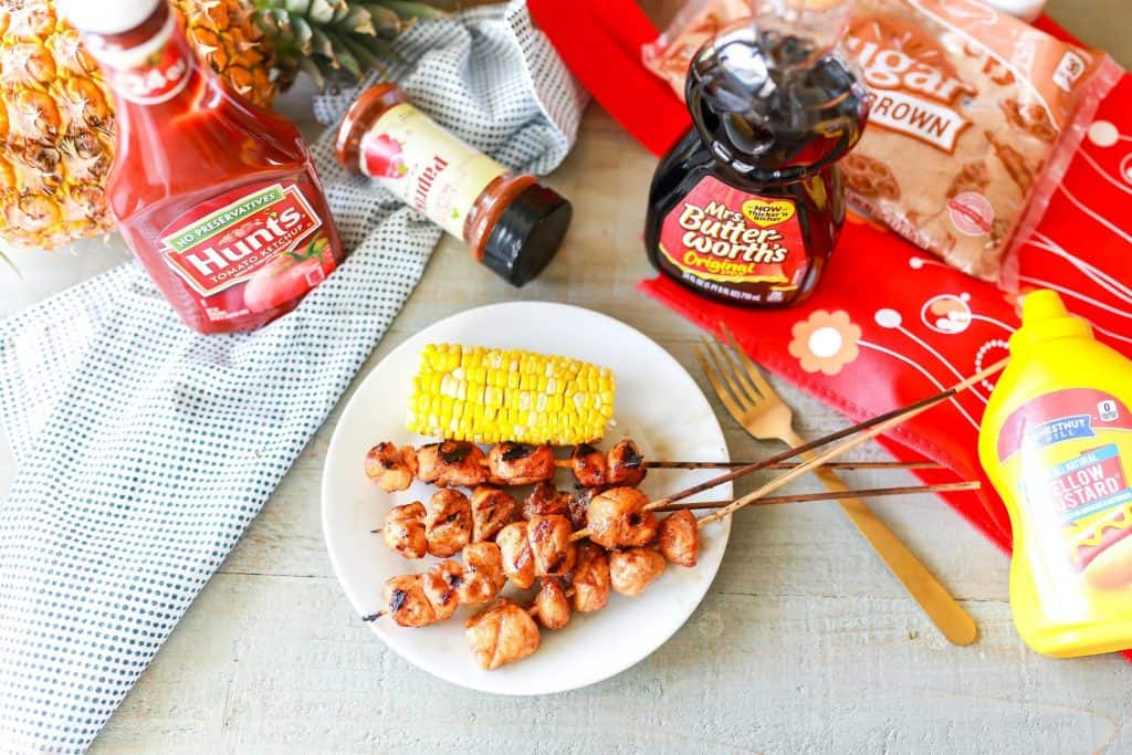 Maple Barbecue Chicken Kabobs on white plate with marinade ingredients on table around the plate