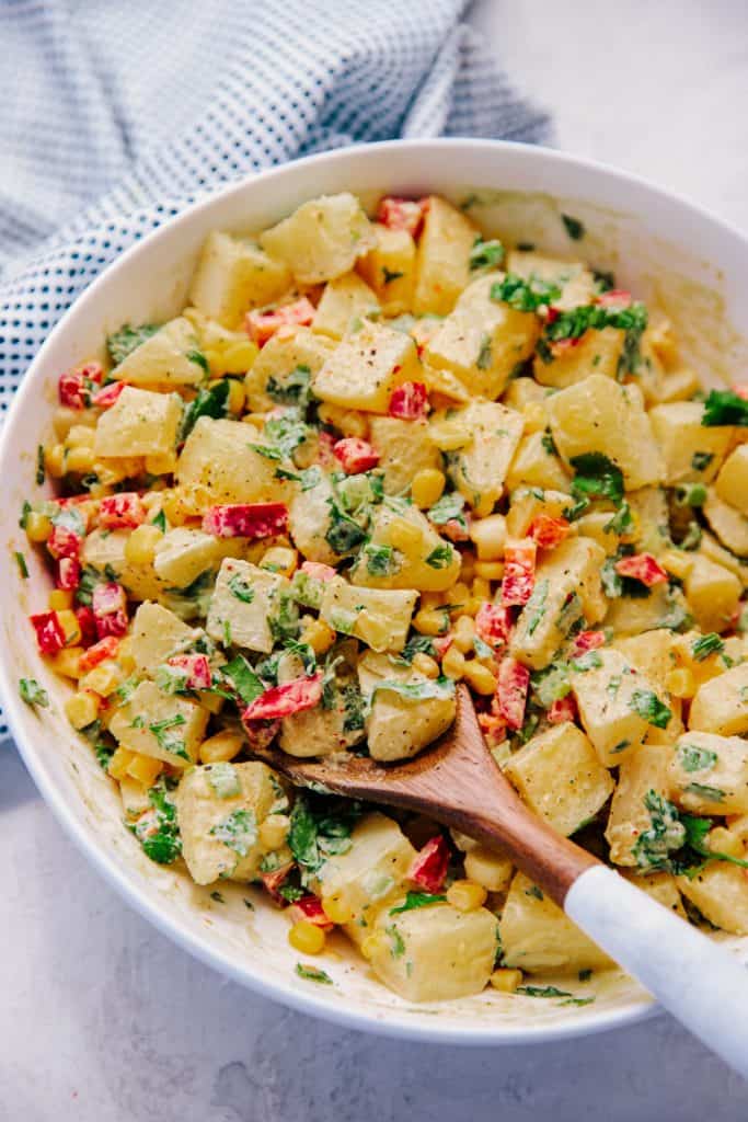 potato salad in a white serving bowl with Tangy Southwest Dressing