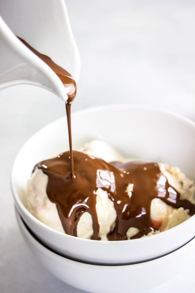 pouring Hard Shell Chocolate over ice cream in a white bowl