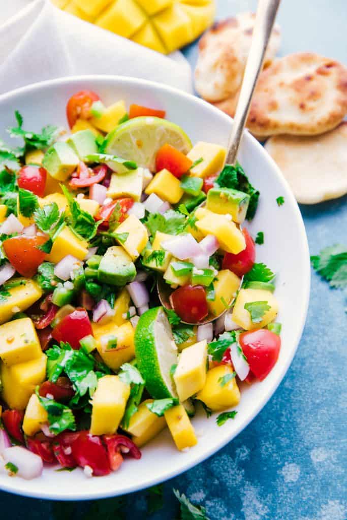 overhead shot mango salsa white bowl with spoon