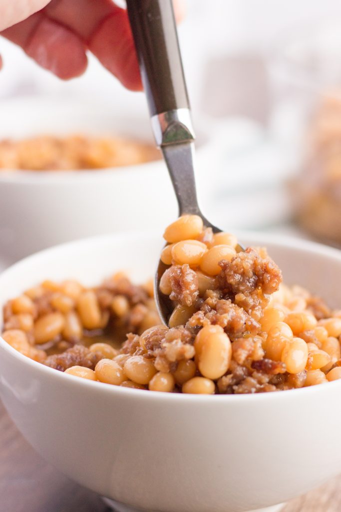 navy beans in a white bowl with a spoonful
