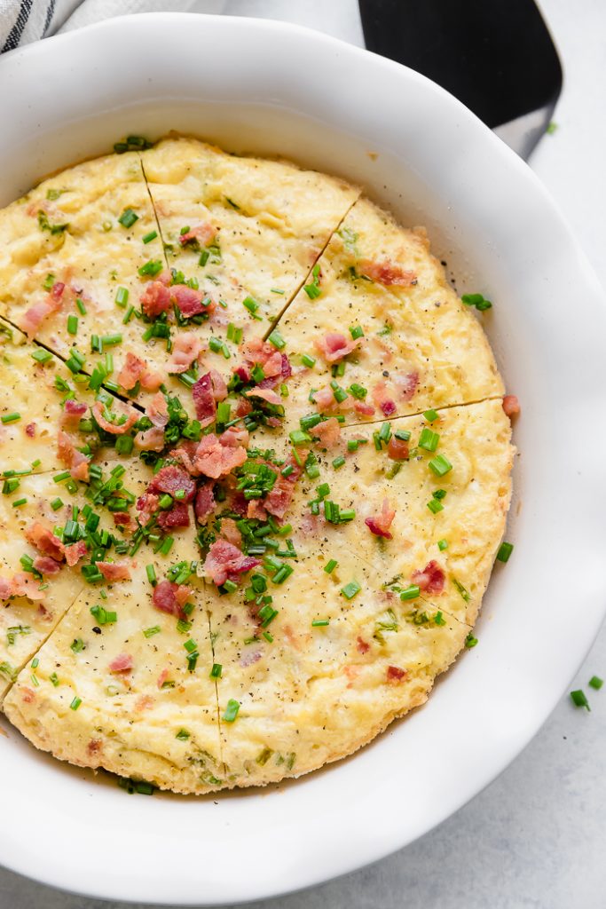 close up of Bacon Chive Crustless Quiche in a white pie pan