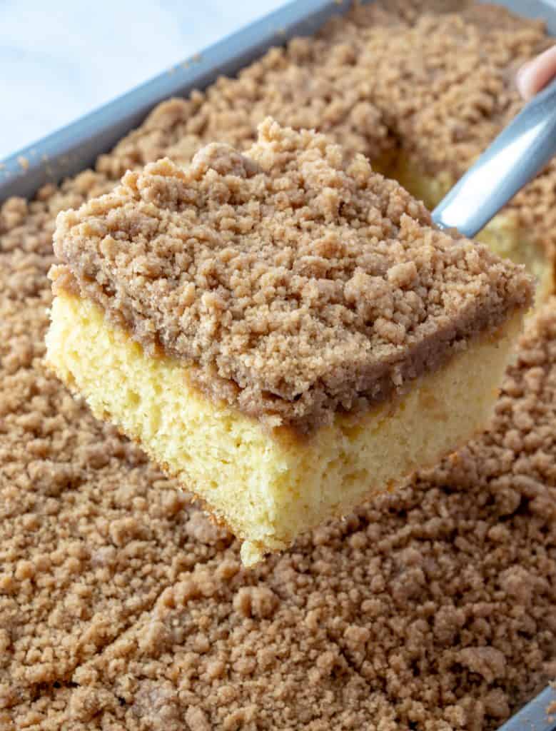 photo showing a slice of Cinnamon Streusel Coffee Cake pulled out of pan on a metal spatula