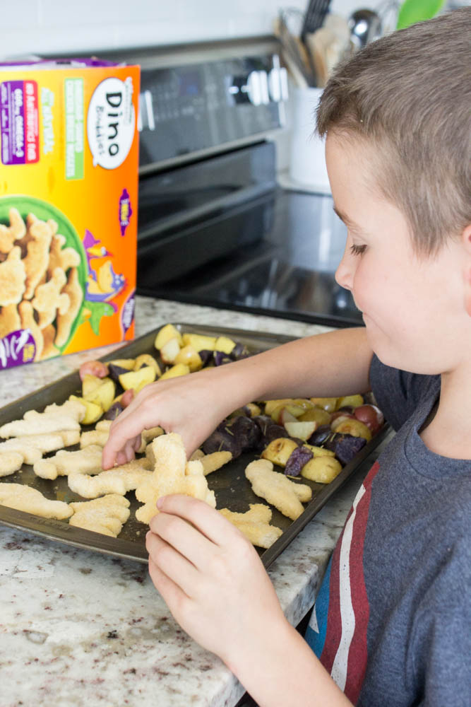 photo of boy arranging dino nuggets on a metal sheet pan