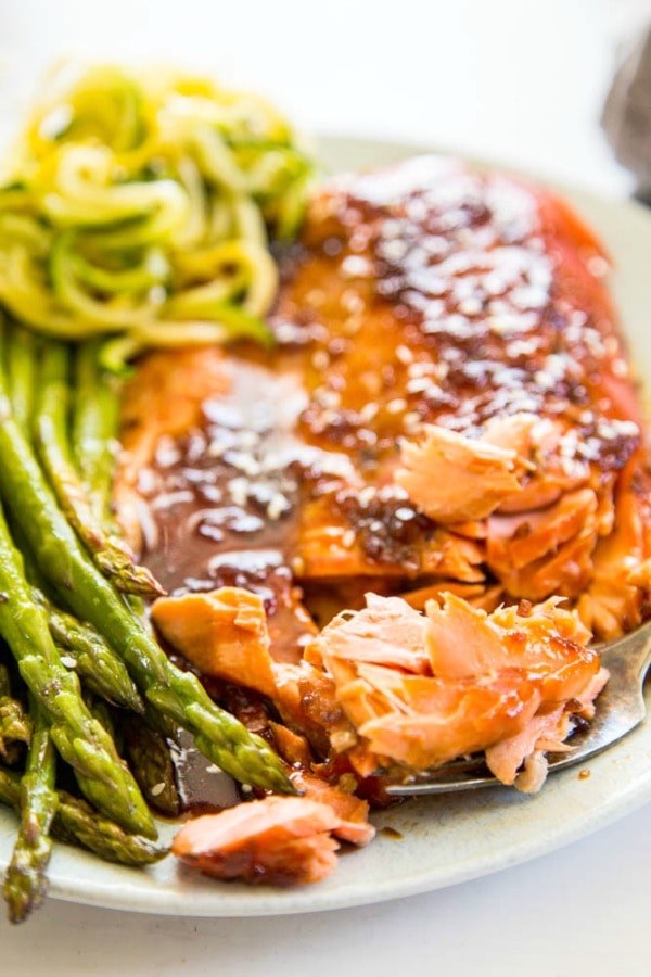 grilled salmon with a side of asparagus and zucchini noodles, salmon has a teriyaki glaze on it
