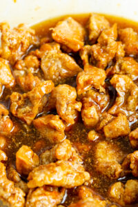 close up shot of crispy honey chicken in sauce