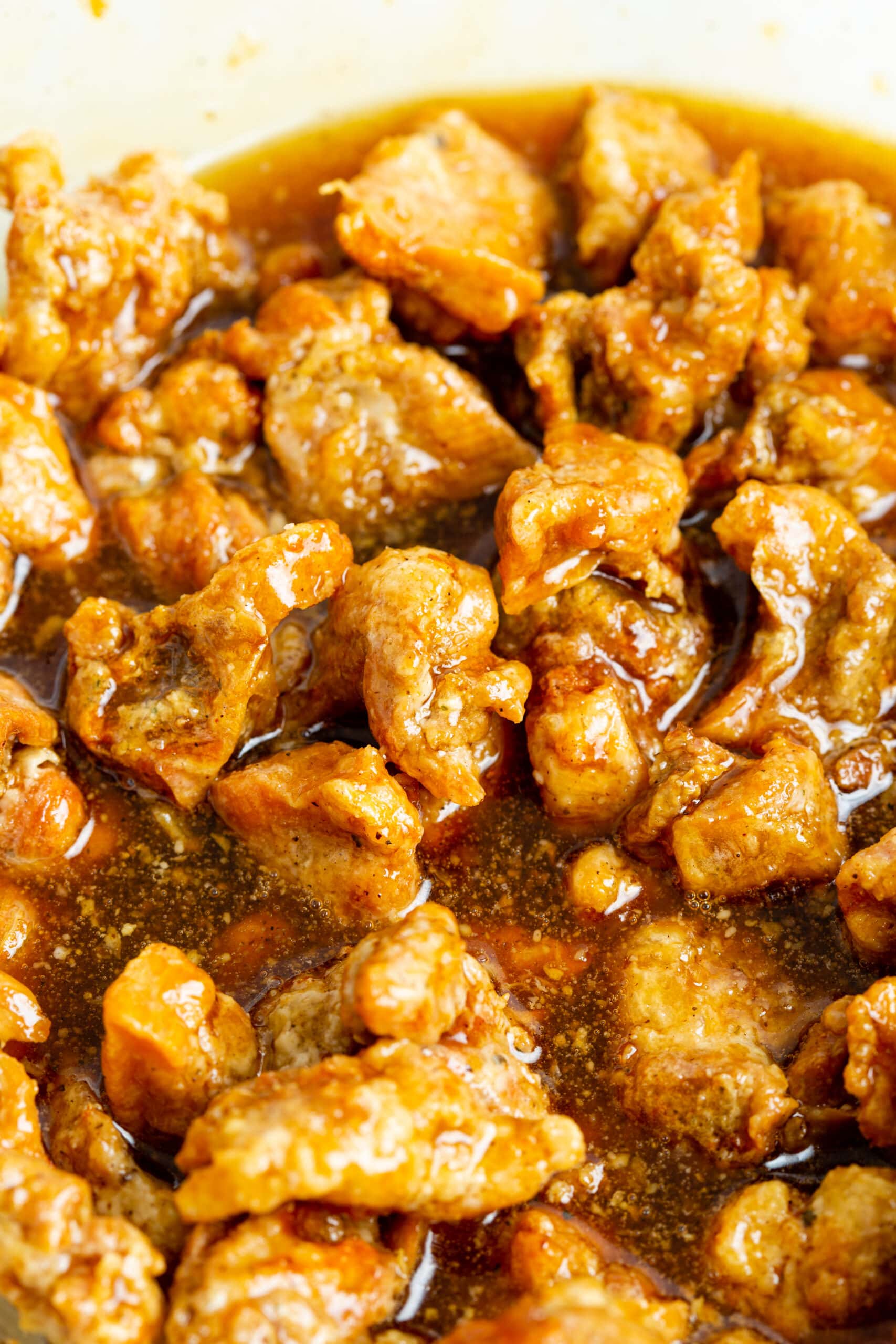 close up shot of crispy honey chicken in sauce