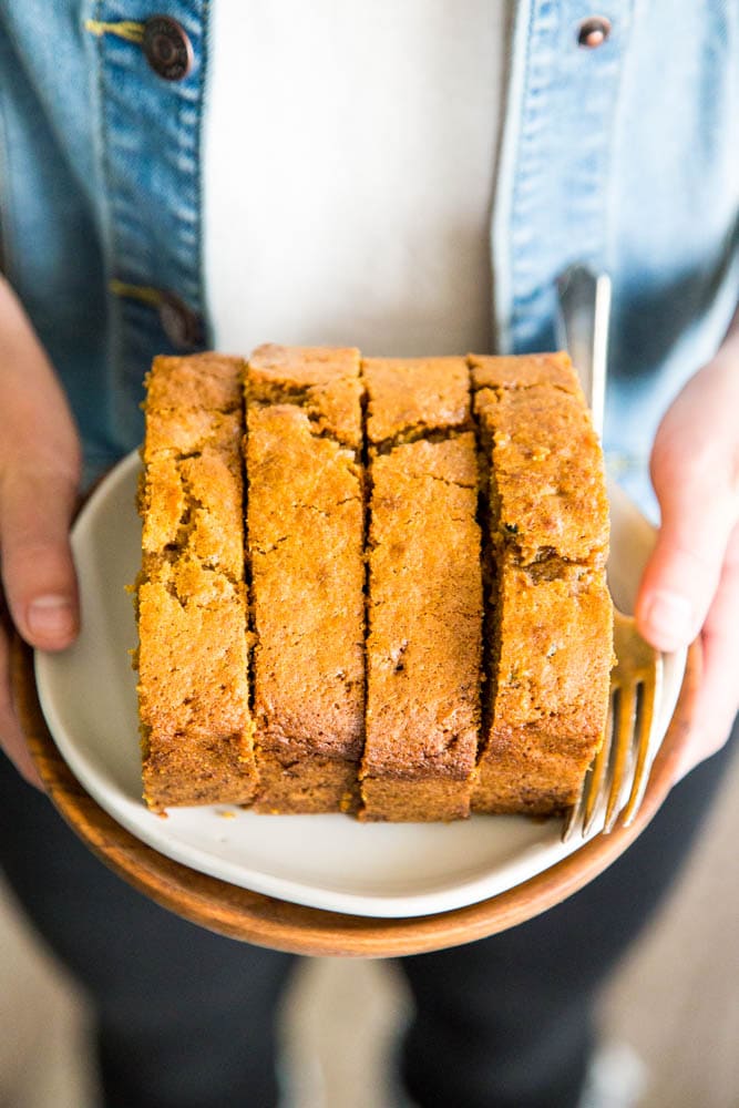 a person holding a plate of sliced bread