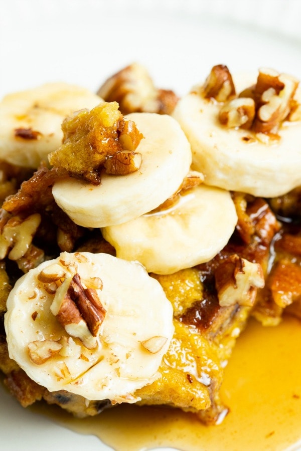 slice of french toast with bananas, nuts and syrup.