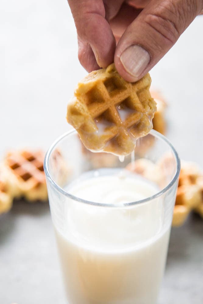 a cookie being lifted out of the glass of milk