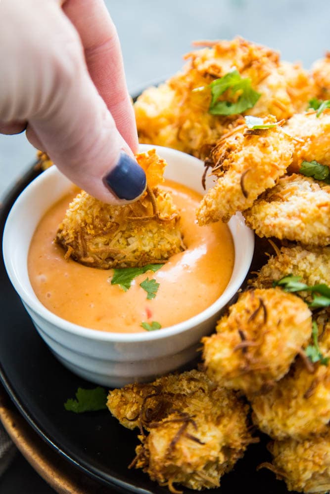 dipping coconut shrimp in sauce
