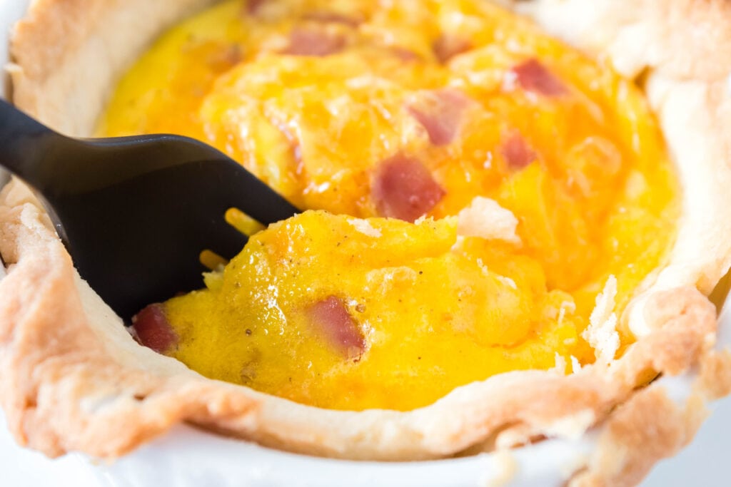 close-up shot of a fork pulling out a piece of quiche.