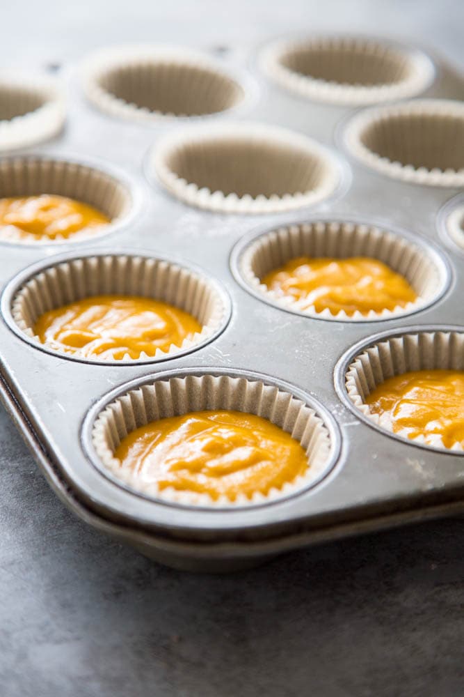 the cupcake liners being filled with batter.