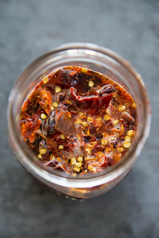 chopped dried chiles soaking in a jar of hot water.