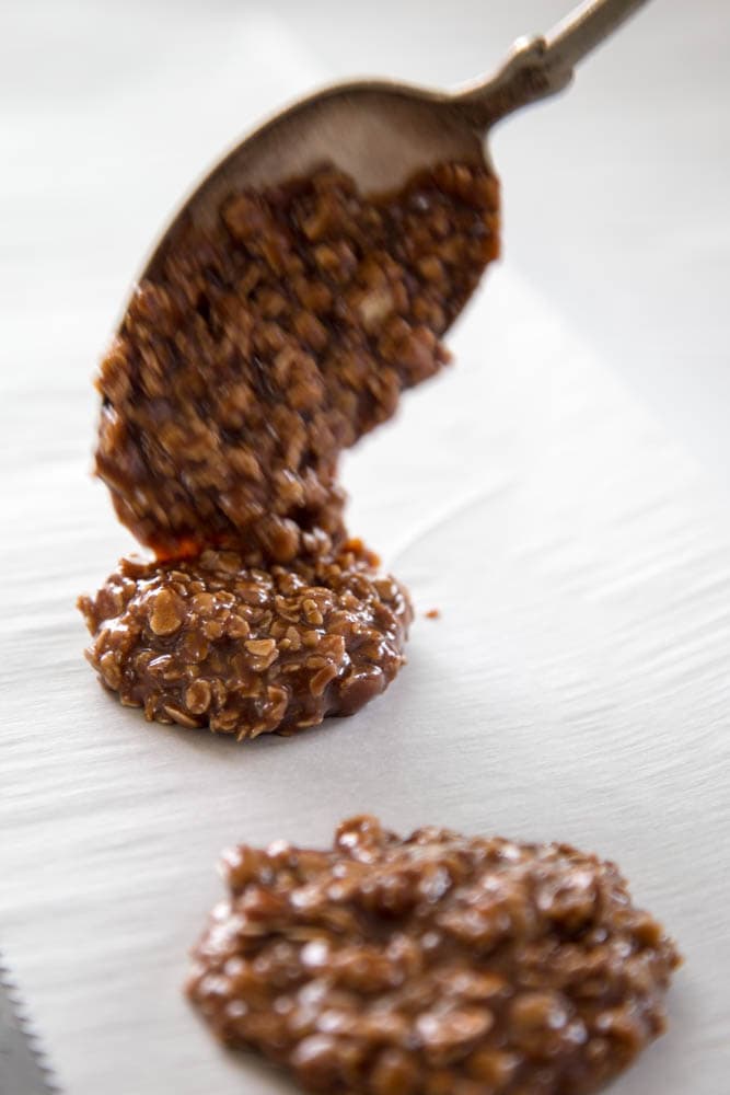 a spoonful of the mixture being dropped into a sheet pan.