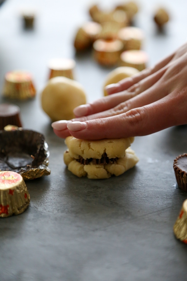 dough being pressed down to make a stuffed cookie.