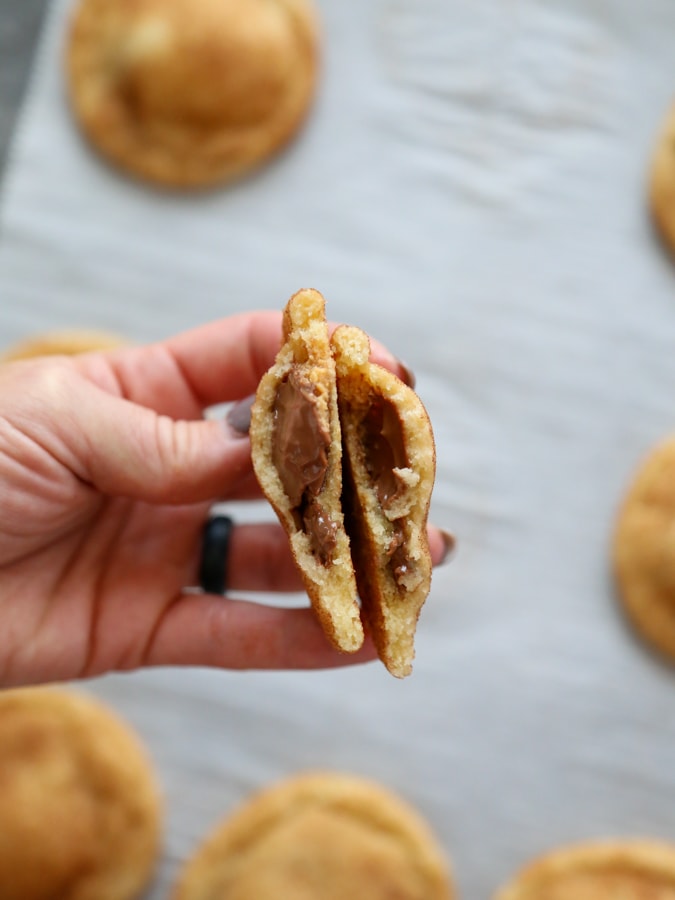a cookie broken in half with a chocolate and peanut butter center.