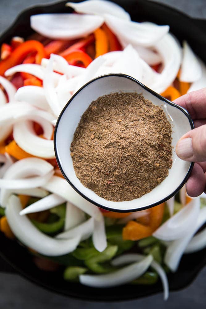 the Cajun seasoning being added to the skillet.
