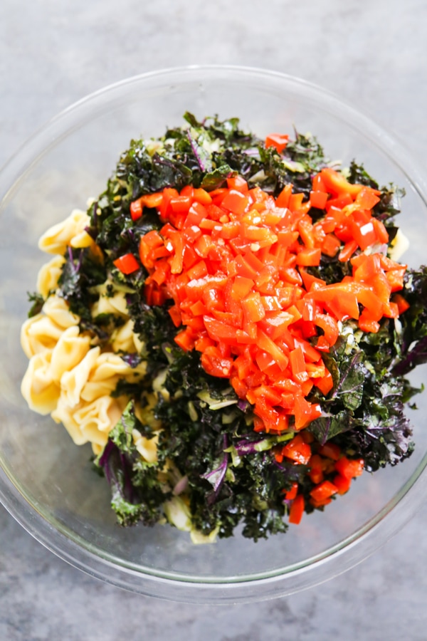 the red pepper being added to the bowl with the other ingredients.