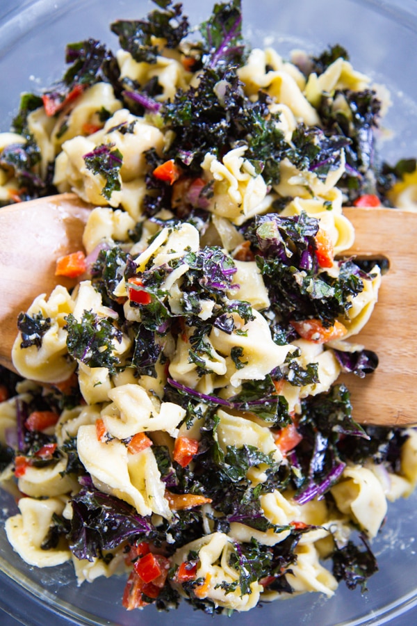 This Kale & Tortellini Pasta Salad is made with fresh kale, roasted red peppers, shallots, garlic, tortellini pasta and a delicious lemon pesto dressing.