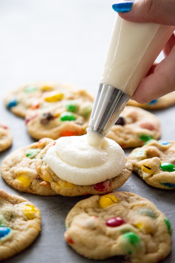 icing being piped onto a cookie.